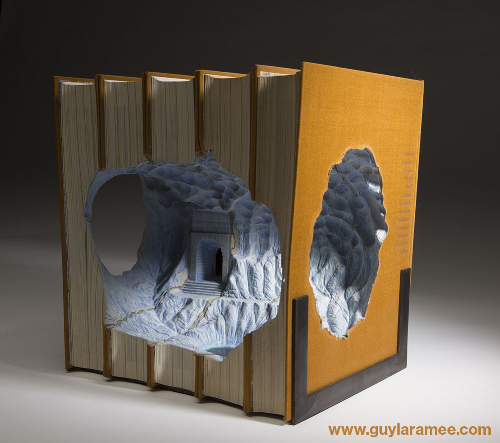 Several books with a carved internal cavity that looks like a temple entrance.